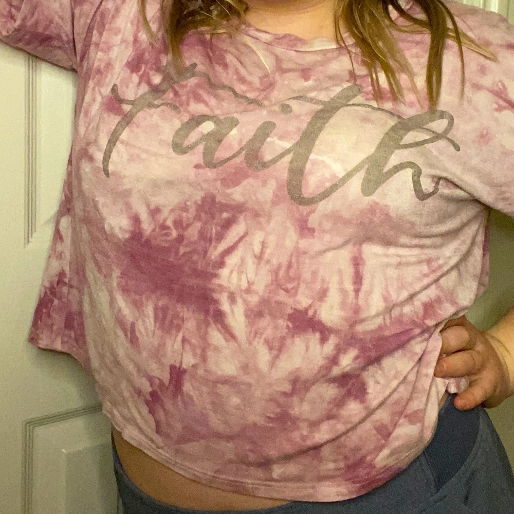 A pink tie-dye shirt, spelling faith on the front, medium sized